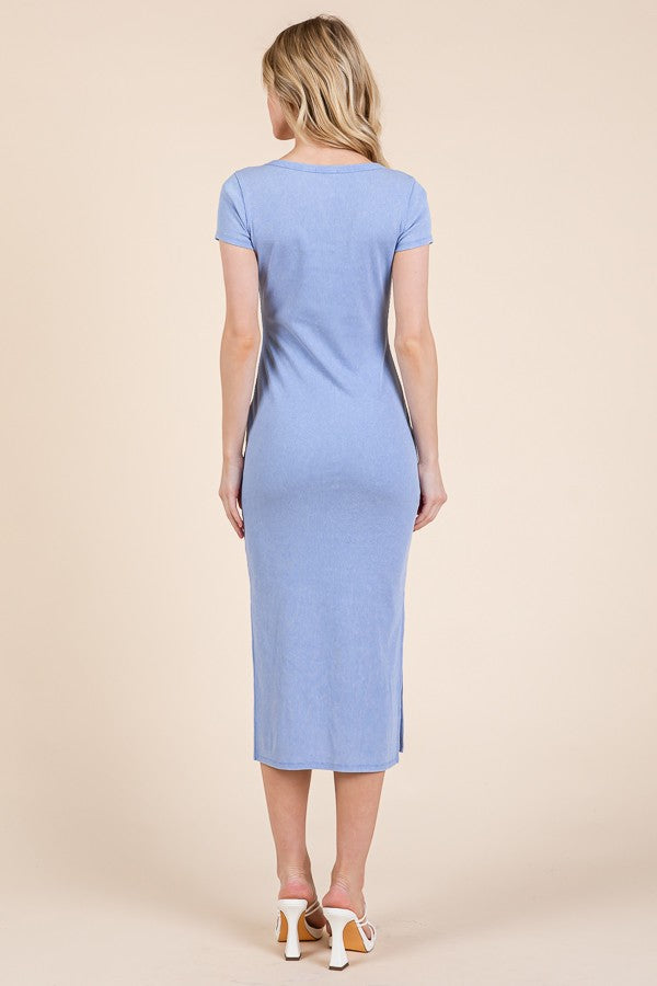 woman wearing a light blue short sleeve fitted midi dress with a side slit, viewed from the back