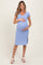 woman wearing a light blue short sleeve maternity dress and holding her baby bump