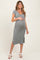 woman wearing a gray ribbed short sleeve maternity dress with a side slit and holding her baby bump