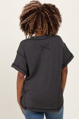 woman wearing a black and gray striped maternity top, styled with short sleeves and a relaxed fit