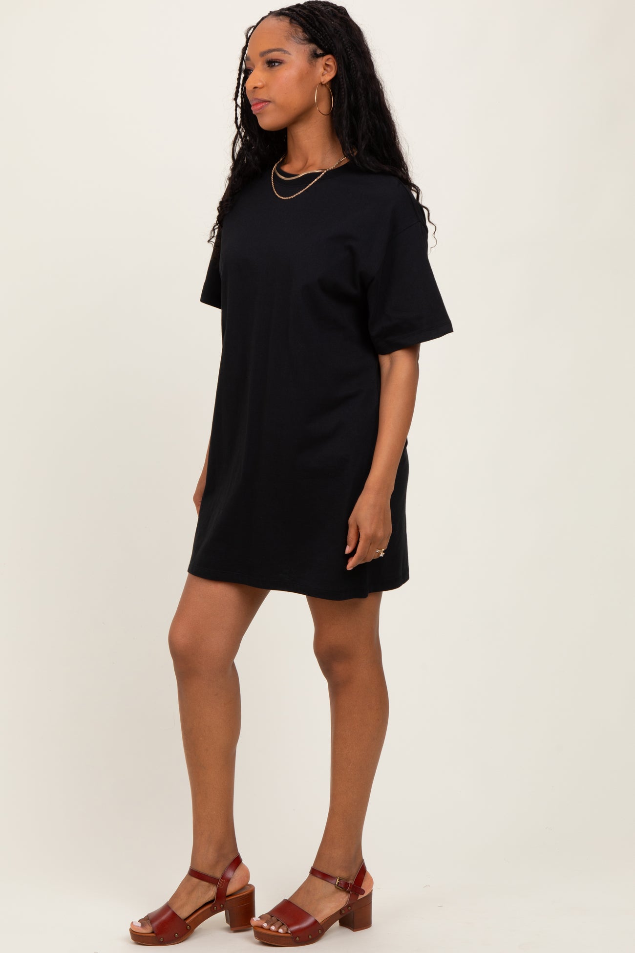 woman wearing a black oversized t-shirt dress with short sleeves and brown chunky heeled sandals