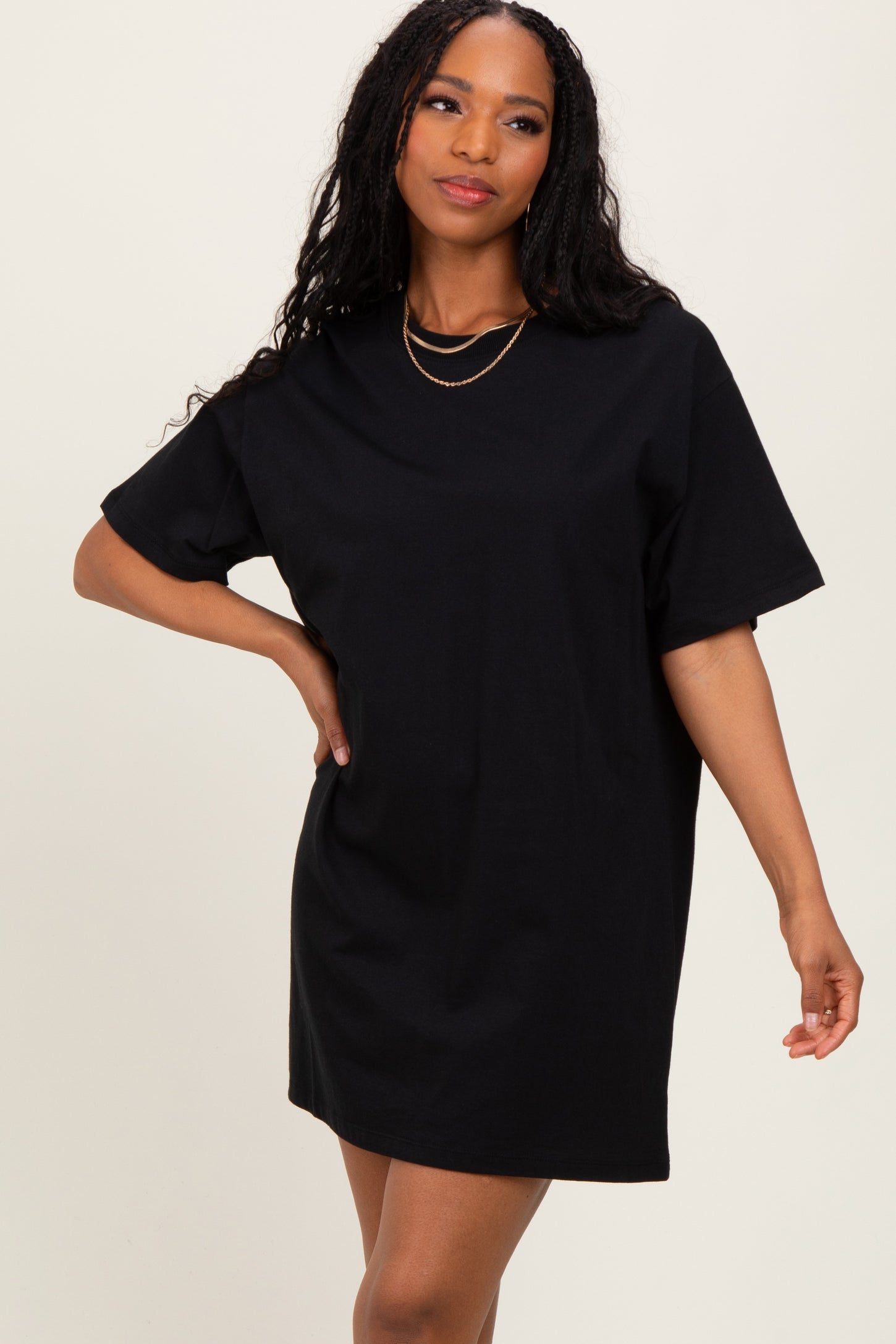 woman wearing a black oversized t-shirt dress with short sleeves and a relaxed fit