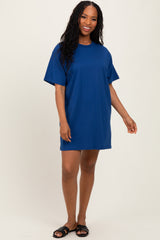 woman wearing a relaxed fit bright blue t-shirt dress with short sleeves and standing in a casual pose