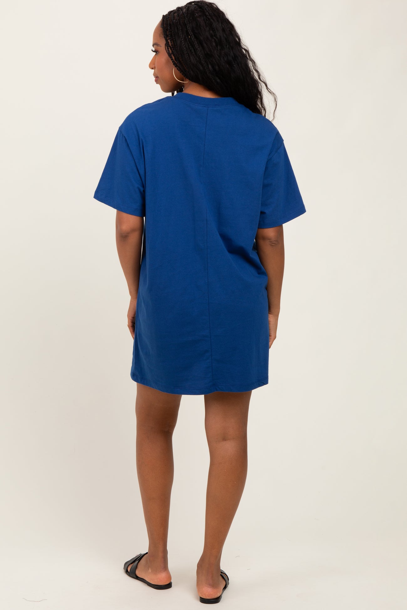 woman wearing a navy blue short sleeve oversized t-shirt dress, standing with her back to the camera