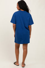 woman wearing a navy blue short sleeve oversized t-shirt dress, standing with her back to the camera