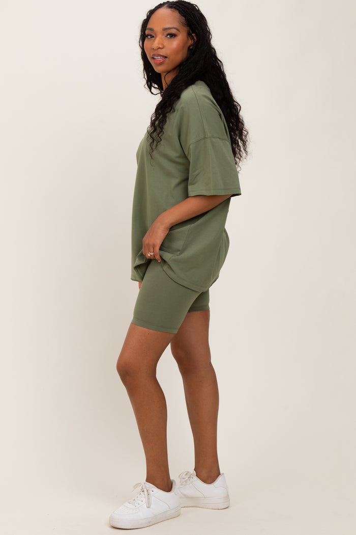 woman wearing an olive green oversized t-shirt and matching bike shorts with white sneakers