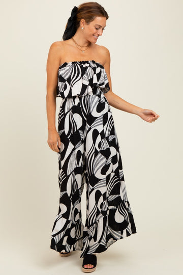 woman wearing a black and white strapless jumpsuit with a ruffled top and wide-leg pants