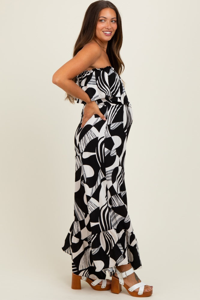 woman wearing a black and white patterned maternity maxi dress with pockets and a ruffled hem, showing her baby bump