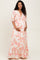 woman wearing a floral maternity maxi dress with puff sleeves and a v-neck, showcasing her baby bump