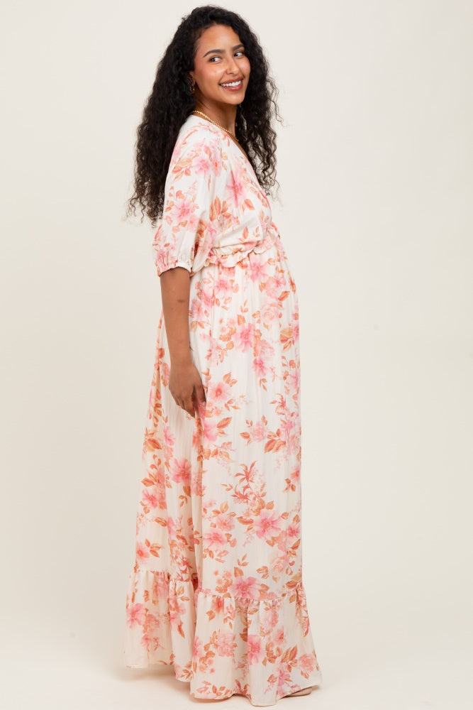 woman wearing a floral maternity maxi dress with a ruffled hem and baby bump visible