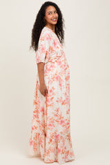 woman wearing a floral maternity maxi dress with a ruffled hem and baby bump visible