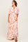 woman wearing a floral print maxi dress with puff sleeves and a deep v-neckline