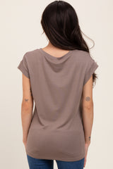woman wearing a taupe maternity top with rolled short sleeves, showing the back view