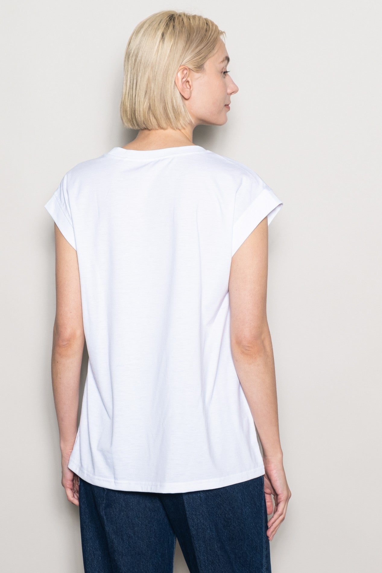 woman wearing a white short sleeve t-shirt viewed from the back with a relaxed fit