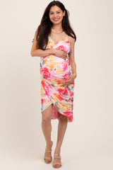 woman wearing a floral print maternity dress with a fitted silhouette and holding her baby bump