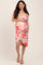 woman wearing a floral print maternity dress with a fitted silhouette and holding her baby bump