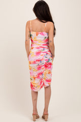 woman wearing a floral print maternity dress with ruched detailing, showing a baby bump from the back