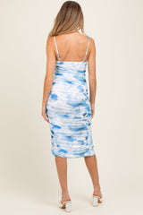 woman wearing a blue and white floral maternity dress with ruching and spaghetti straps, showing off her baby bump