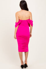 woman wearing a hot pink off-the-shoulder bodycon dress with ruched detailing and a fitted silhouette