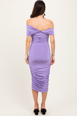 woman wearing a lavender off-shoulder bodycon dress with ruched details and mid-calf length