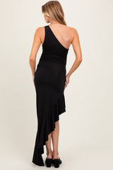 woman wearing a black one-shoulder maternity dress with a ruffled hem, showcasing her back