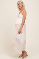 woman wearing a floral patterned maternity maxi dress with lace details and a visible baby bump