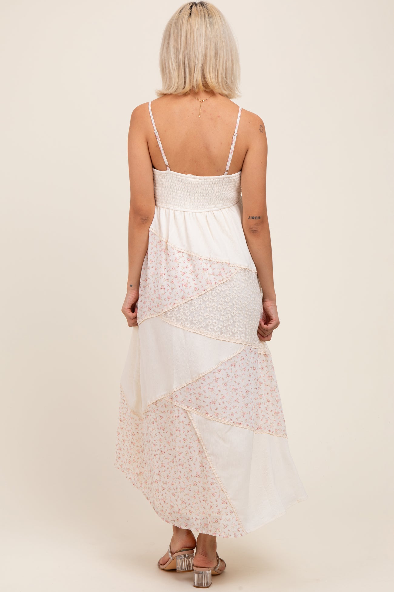 woman wearing a long floral patchwork maternity maxi dress with thin straps and a smocked bodice