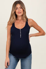 woman wearing a navy blue maternity tank top with button details and a visible baby bump