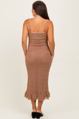 woman wearing a brown fitted maternity dress with ruffled hem and spaghetti straps, showing a baby bump from the back