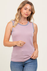 woman wearing a lavender ribbed tank top with a contrasting blue neckline and light blue jeans