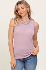 woman wearing a light pink sleeveless ribbed top with blue accents and blue jeans