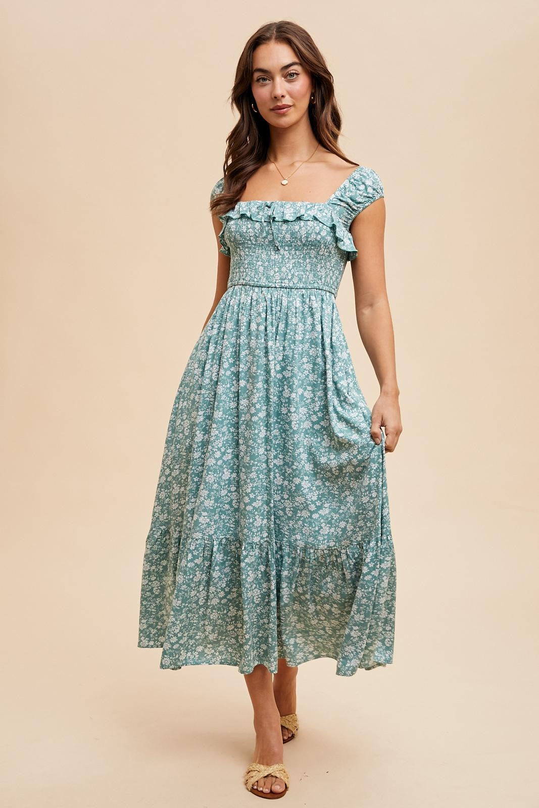 woman wearing a light blue floral midi dress with ruffled sleeves and a fitted bodice
