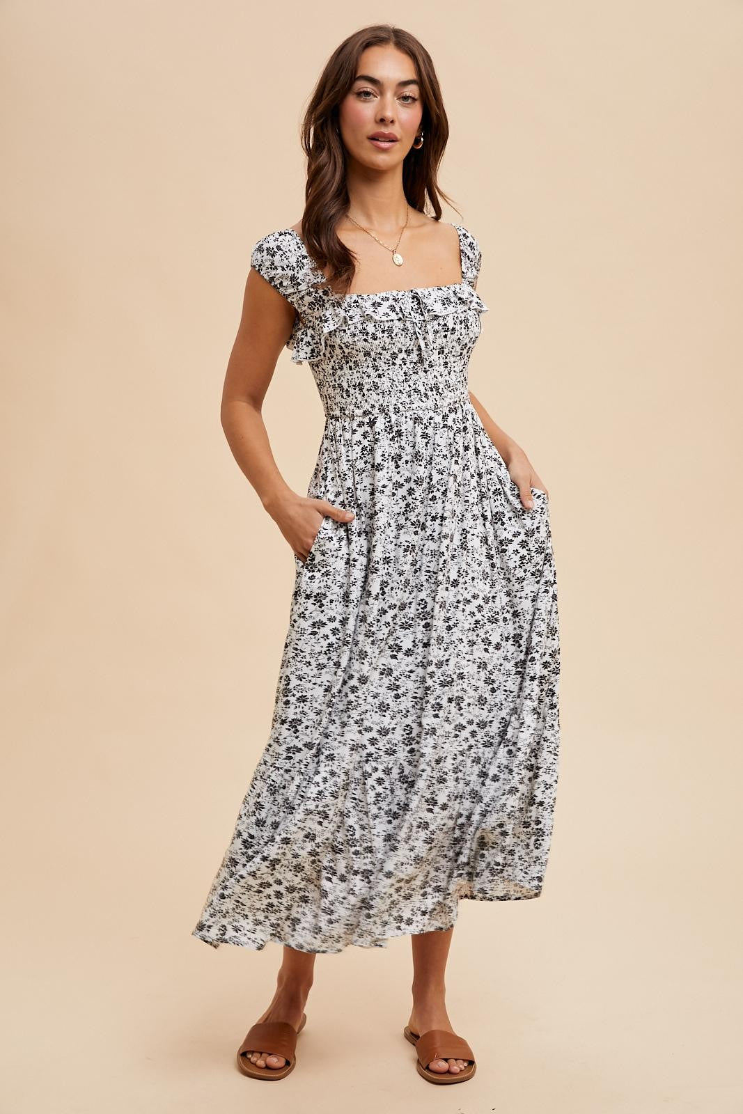 woman wearing a black and white floral maxi dress with a smocked bodice and pockets