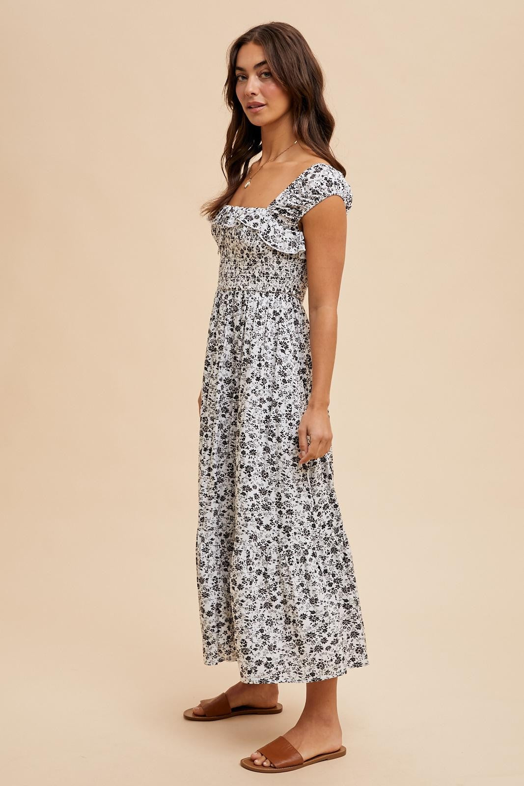 woman wearing a black and white floral maxi dress with short sleeves and square neckline