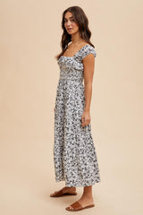 woman wearing a black and white floral maxi dress with short sleeves and square neckline