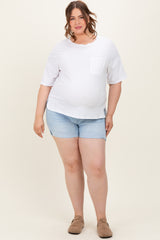 woman wearing a white short sleeve maternity top with a pocket and light blue denim shorts, showing her baby bump