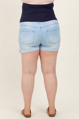 woman wearing light blue maternity plus shorts with a navy blue high waistband, showing her back