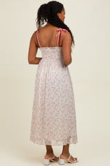 woman wearing a floral maxi dress with adjustable tie straps and smocked back detailing, shown from the back