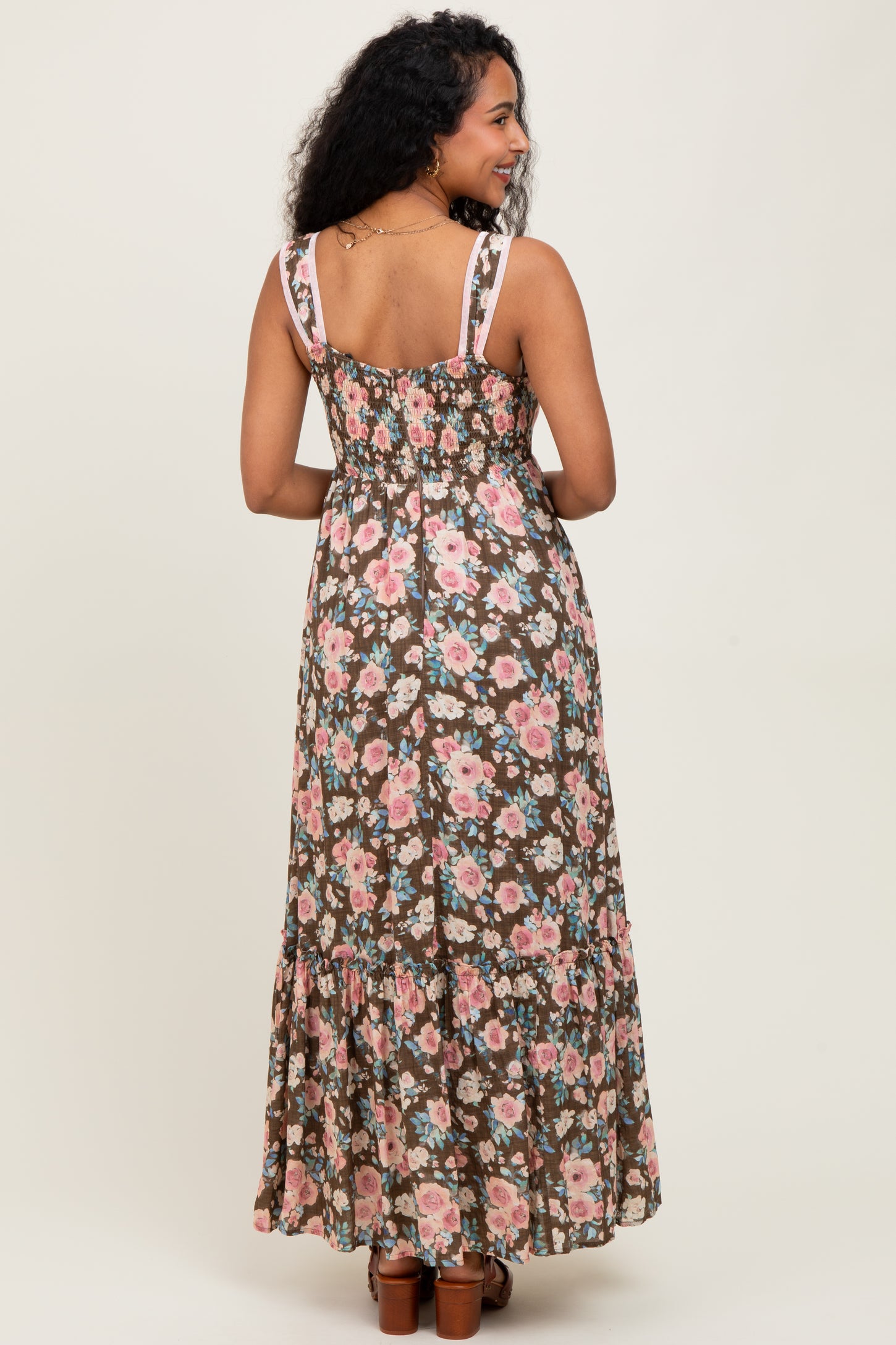 woman wearing a brown floral print maternity maxi dress with a smocked bodice and ruffled hem