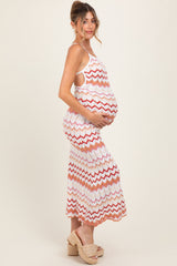 woman wearing a multicolored zigzag patterned maternity dress, showing her baby bump