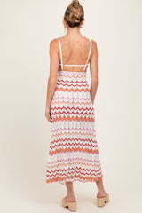 woman wearing a maternity zigzag patterned maxi dress with a strappy back, showing a baby bump