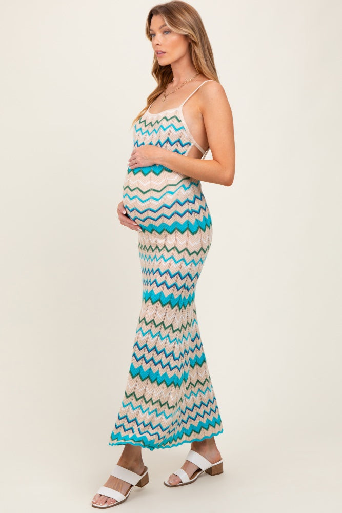 woman wearing a multicolored zigzag patterned maternity dress and holding her baby bump