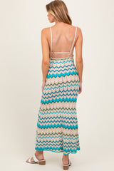 woman wearing a colorful zigzag patterned maternity maxi dress with a backless design and spaghetti straps