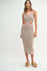 woman wearing a multicolored striped midi dress with cut-out details and pink trim, styled with woven platform sandals