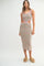 woman wearing a multicolored striped midi dress with cut-out details and pink trim, styled with woven platform sandals
