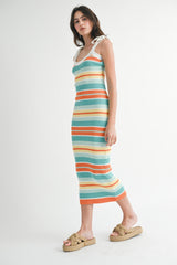 woman wearing a striped ribbed midi dress with tie straps in blue, orange, and white, paired with straw sandals