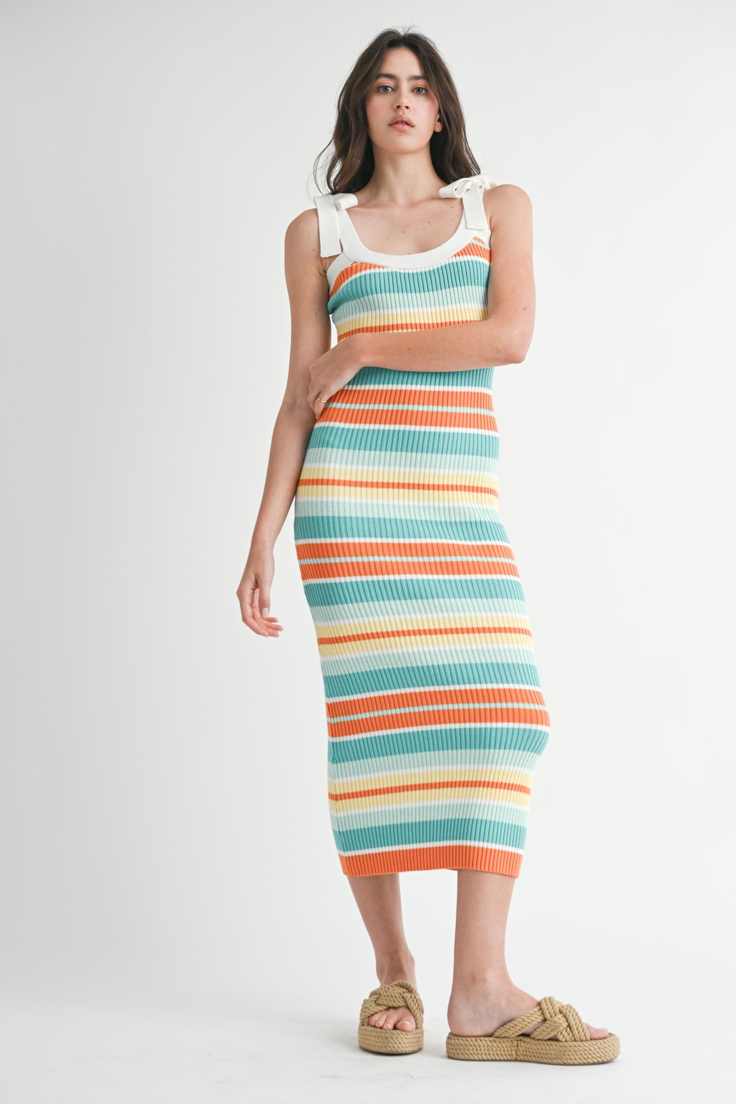 woman wearing a multicolored striped ribbed knit midi dress with white straps and tan slip-on sandals