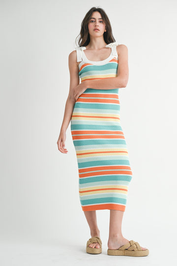 woman wearing a multicolored striped ribbed knit midi dress with white straps and tan slip-on sandals