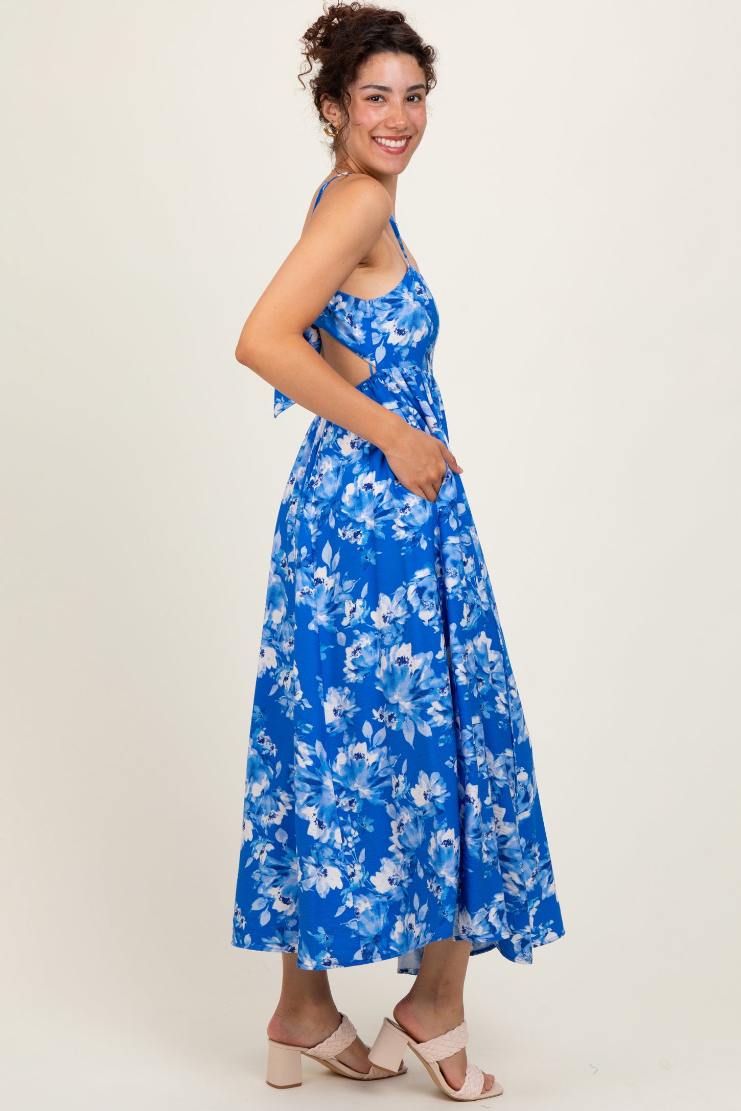 woman wearing a blue floral maxi dress with a flowy skirt and spaghetti straps