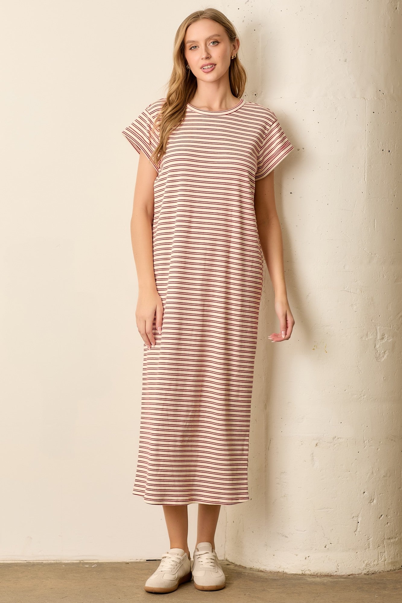woman wearing a pink and white striped maxi dress with short sleeves and a relaxed fit